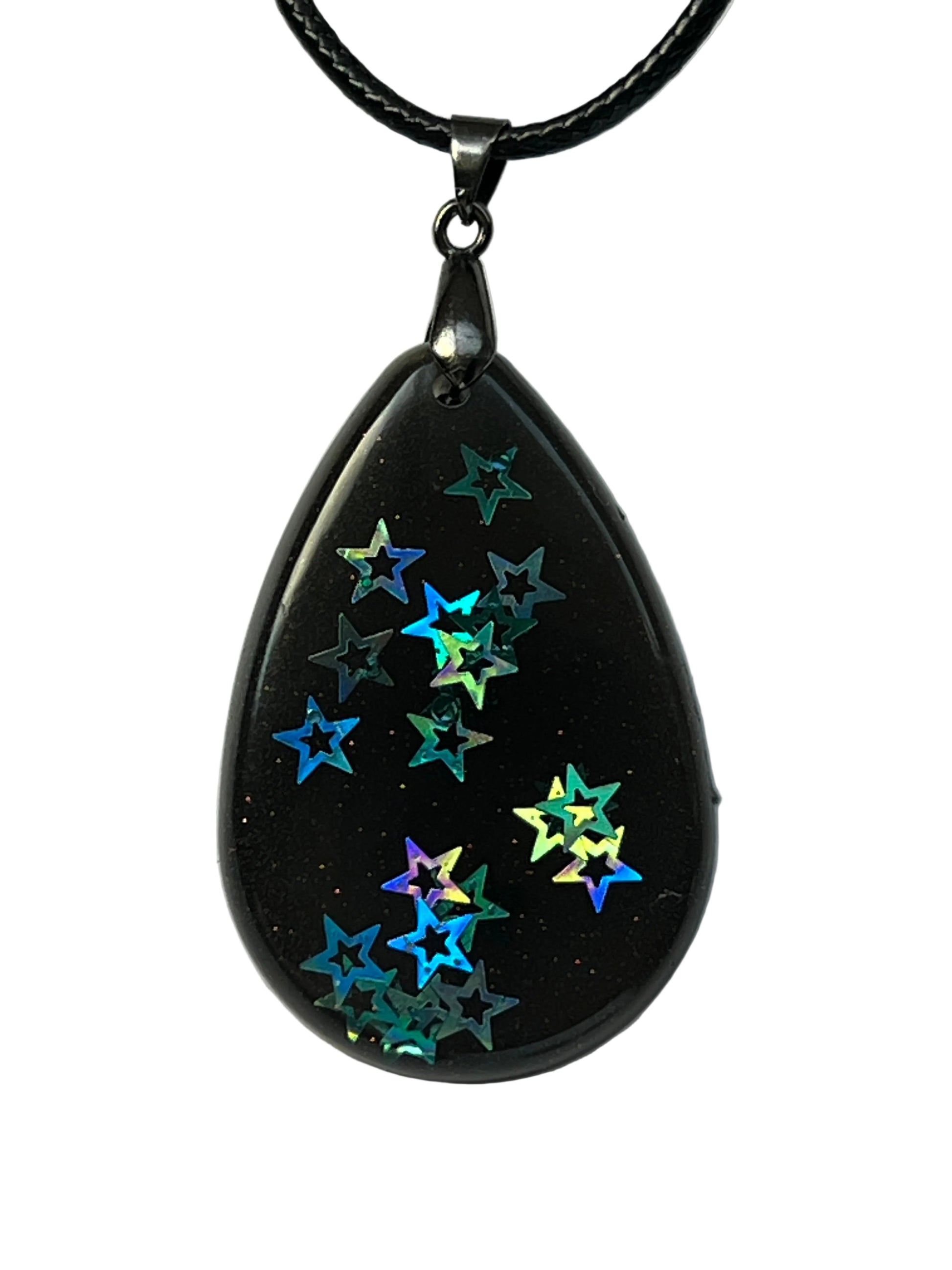 Handcrafted black resin teardrop pendant with holographic star confetti inclusions in teal, blue, purple, and gold, suspended from a black braided cord with a gunmetal bail.