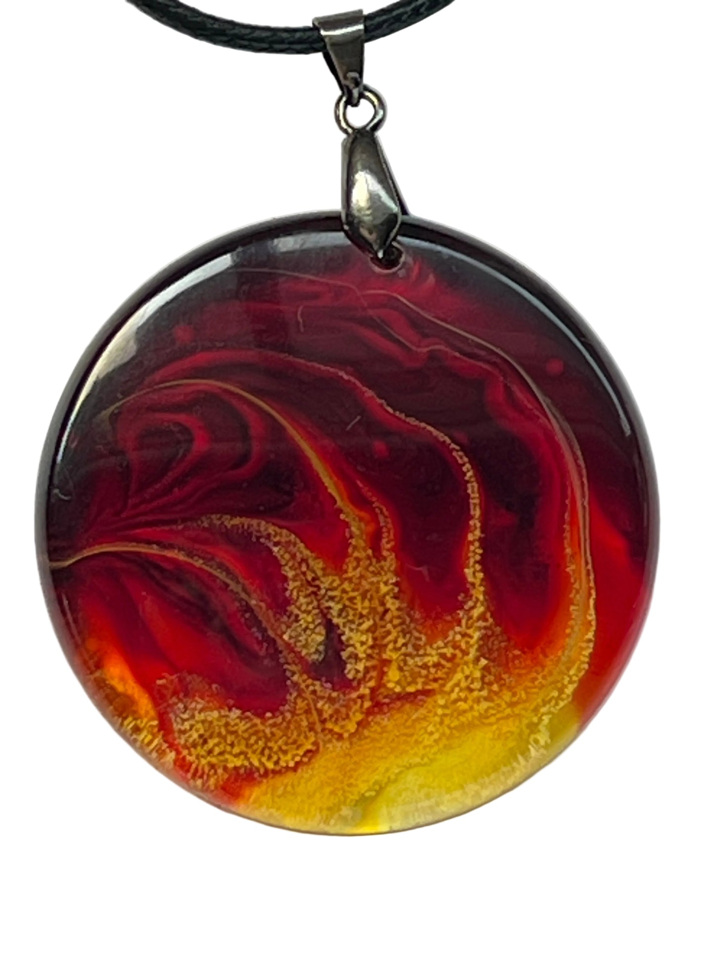 Handcrafted circle resin pendant with deep crimson and orange marbled swirls and an electric yellow and gold glitter core, suspended from a silver chain with a silver-toned bail.