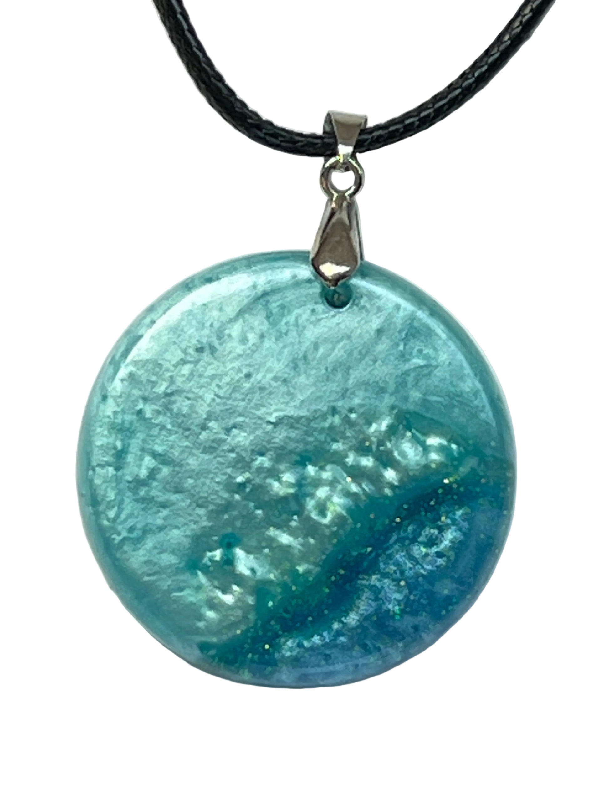 Handcrafted circle resin pendant with pearl aqua, teal, and deep cobalt blue organic foam texture with gold and green glitter flecks, suspended from a silver chain with a silver-toned bail.