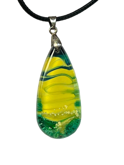 Handcrafted teardrop resin pendant with electric yellow center ribboned with deep forest green swirls and a textured teal base, suspended from a black braided cord with a silver-toned bail.