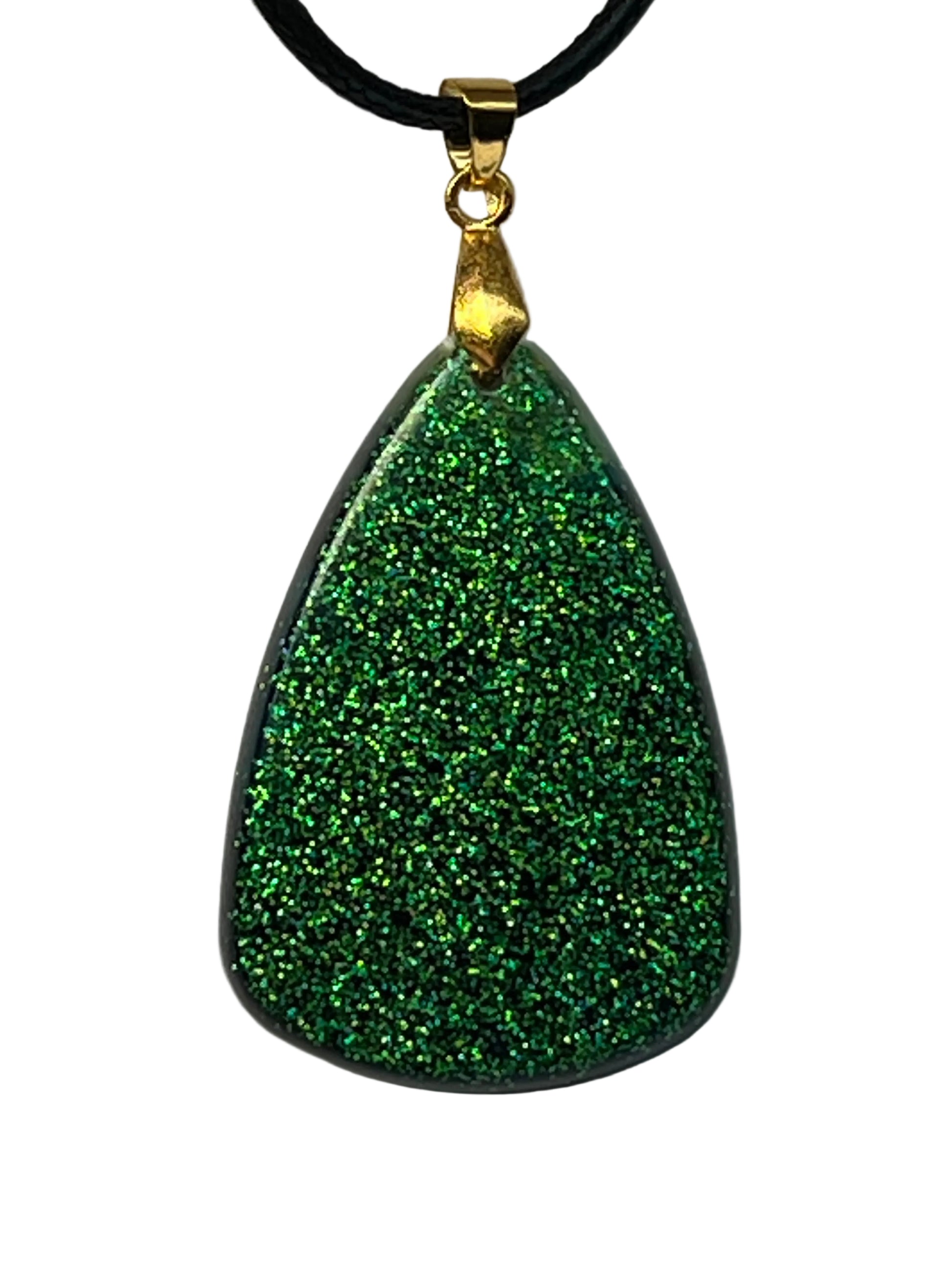 Handcrafted resin wide teardrop pendant displaying dense holographic emerald green glitter in direct light that transforms to deep midnight blue with scattered gold star glitter under shifting light, suspended from a black braided cord with a gold-toned bail.