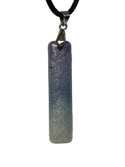 Handcrafted resin elongated bar pendant with soft amethyst purple at the top fading through periwinkle into luminous silver-white at the base with fine pearlescent shimmer throughout, suspended from a black braided cord with a silver-toned bail.