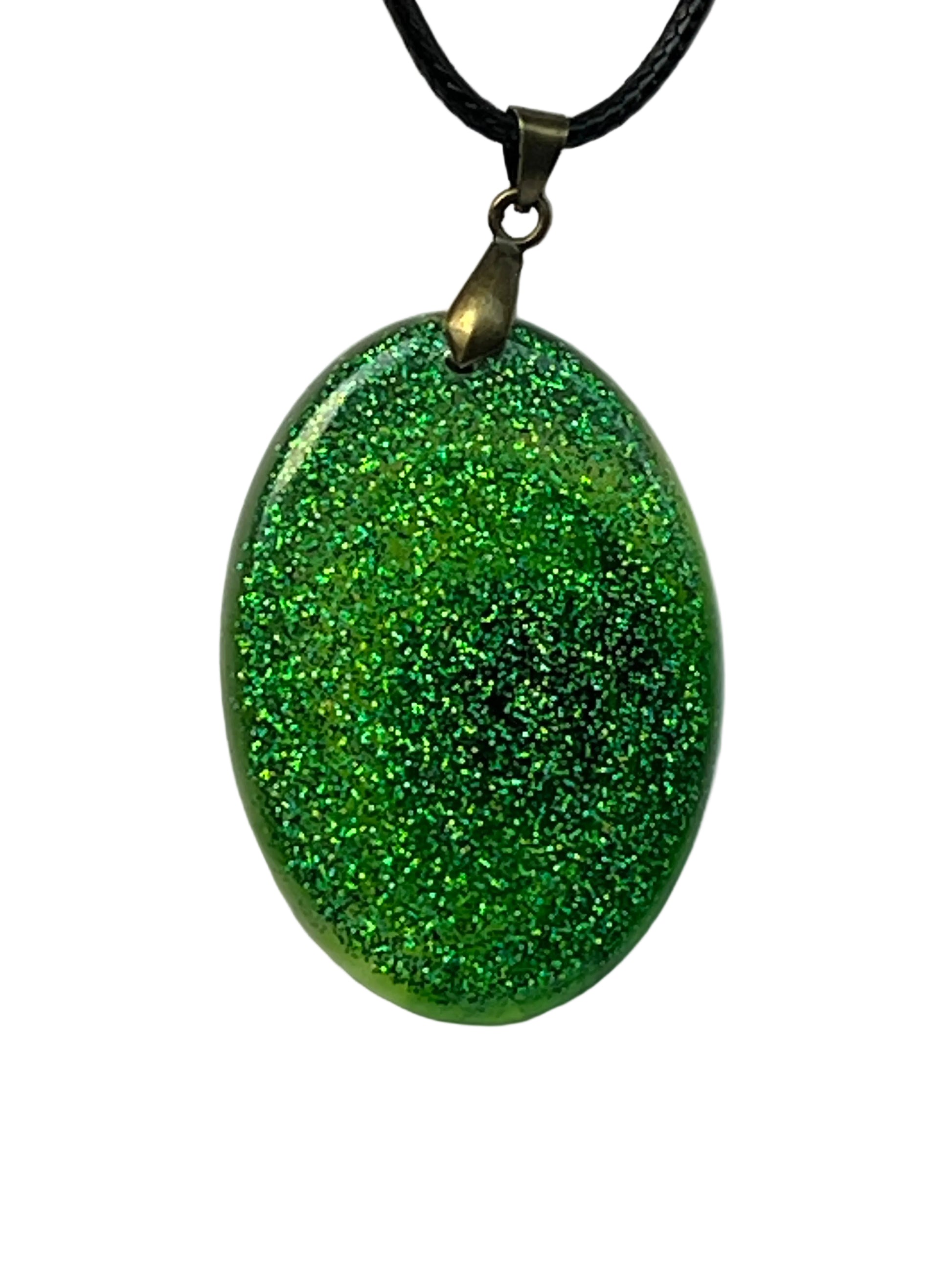 Handcrafted emerald green holographic glitter resin oval pendant with a mesmerizing dark spiral vortex at the center, suspended from a black braided cord with an antique bronze bail.

