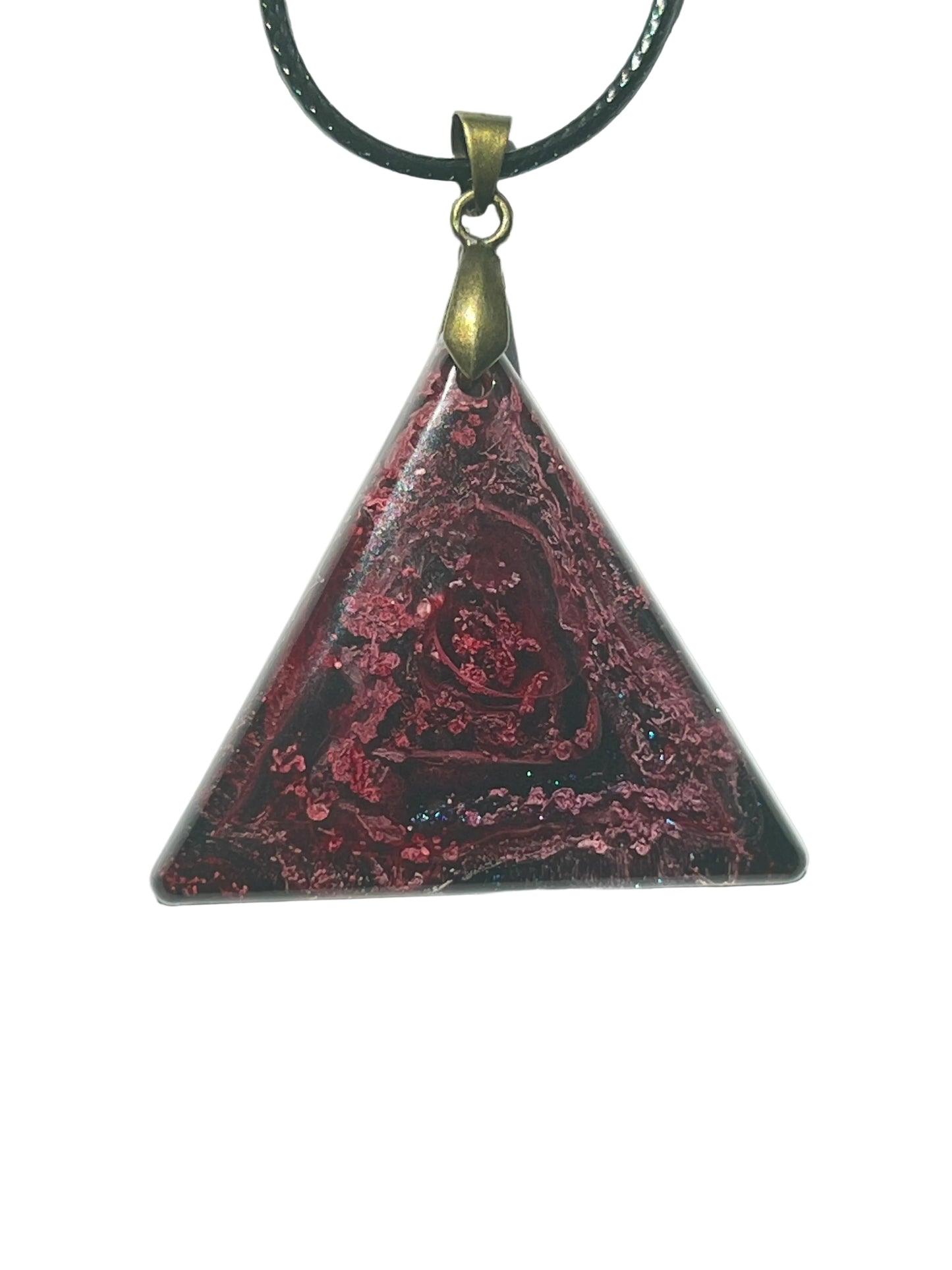 Handcrafted resin triangle pendant with deep black base featuring a swirling crimson and magenta rose pattern with scattered hot pink glitter and a deep blue iridescent accent along the base, suspended from a black braided cord with an antique bronze bail.
