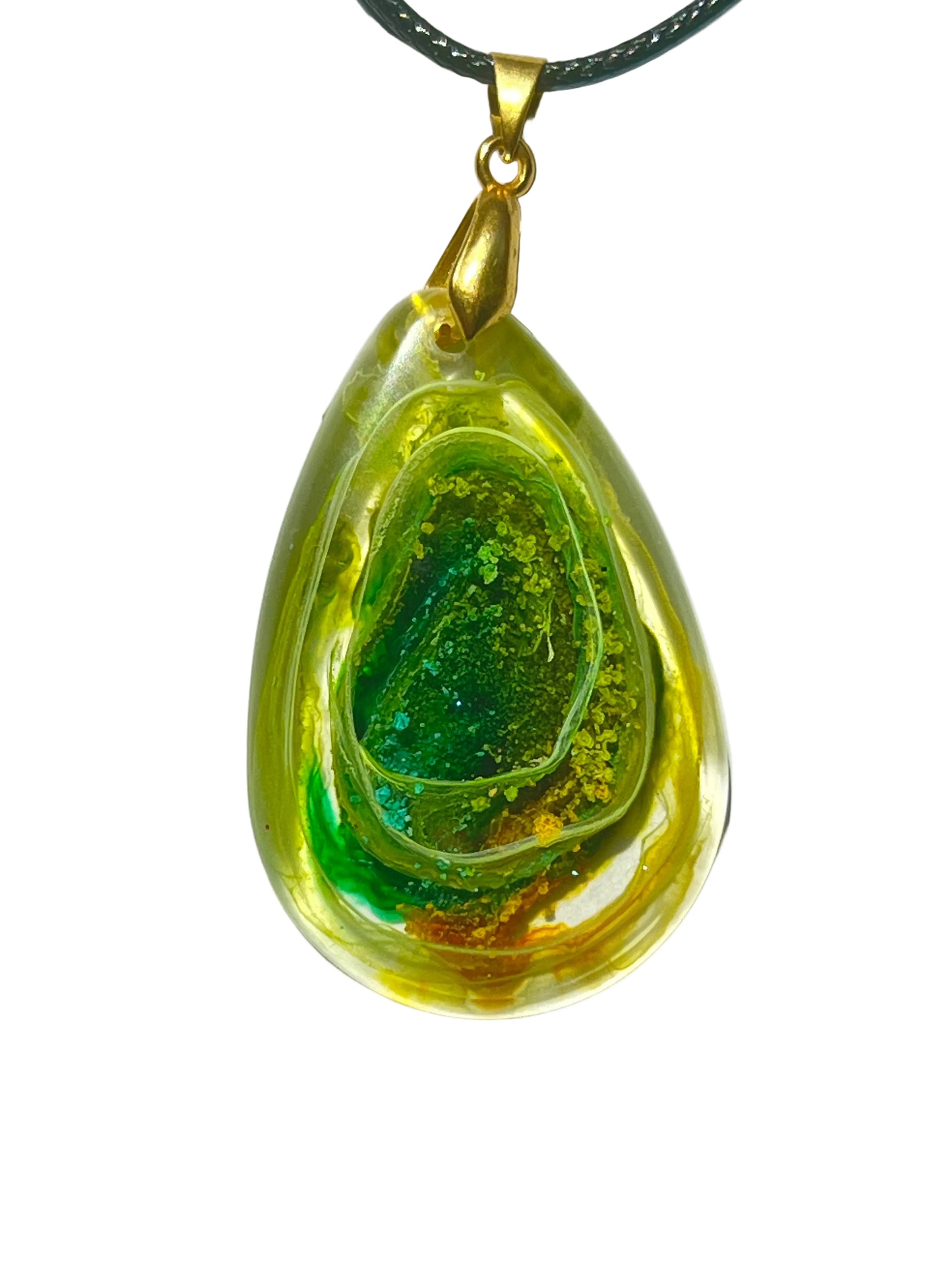 Handcrafted resin teardrop pendant with translucent golden yellow outer layer revealing a layered green geode-like interior cavity with emerald and teal glitter crystal center, suspended from a black braided cord with a gold-toned bail.