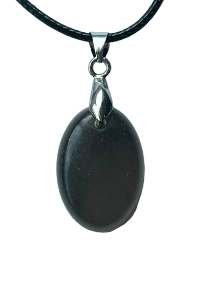 Handcrafted deep matte charcoal grey resin oval pendant with fine texture and subtle micro-sparkle giving a polished dark stone-like quality, suspended from a black braided cord with a silver-toned bail.

Next one whenever you're ready! 🌙✨