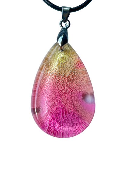 Handcrafted large resin teardrop pendant with translucent pale yellow apex fading through peachy coral into vivid hot pink and magenta base with intricate fine cellular texture throughout and natural clear window formations, suspended from a black braided cord with a silver-toned bail.