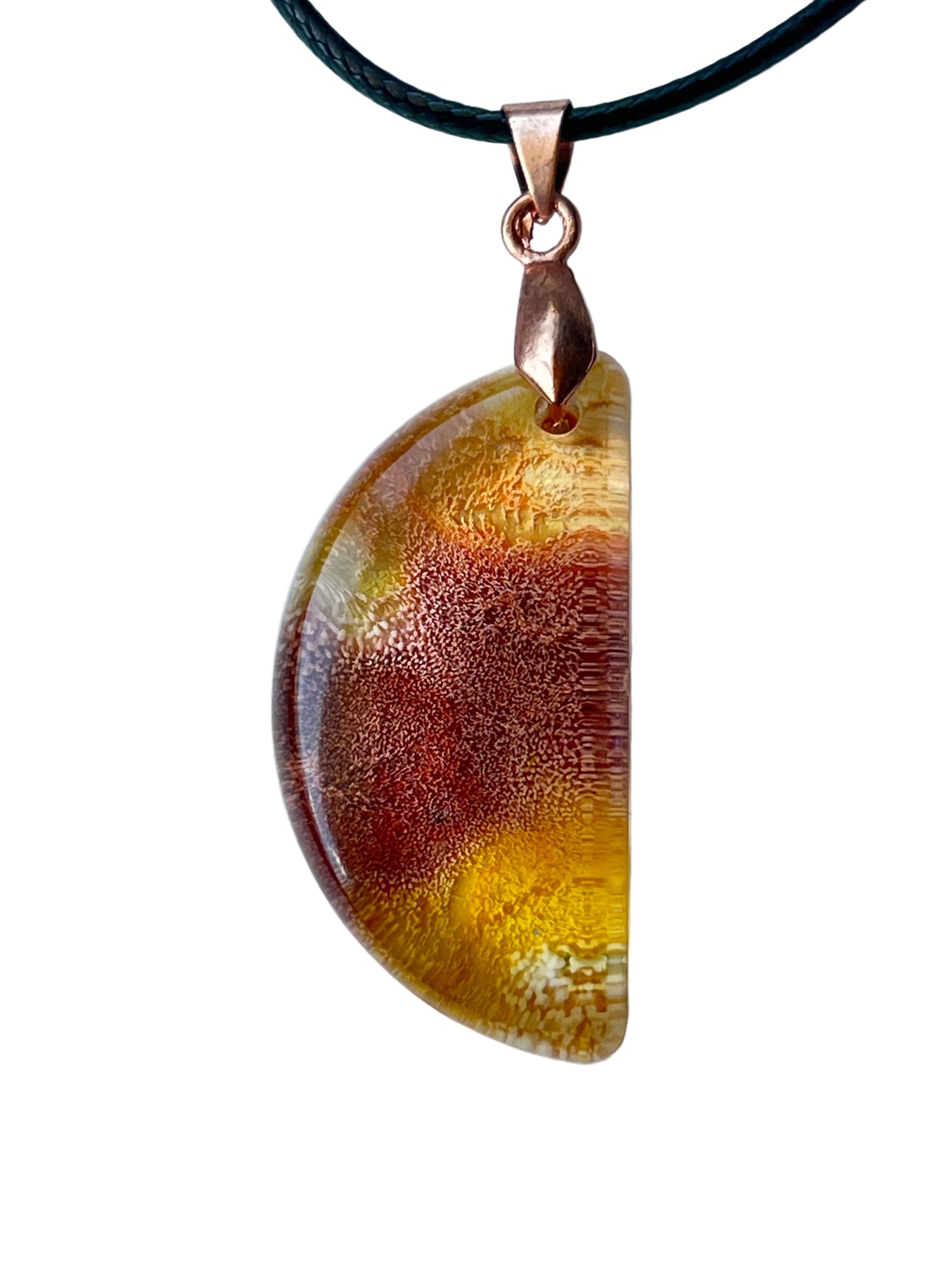 Handcrafted rich translucent golden amber resin half moon pendant with a sweeping deep copper and burnt sienna shimmer formation and fine woven texture throughout glowing translucent edges, suspended from a dark braided cord with a copper-toned bail.
