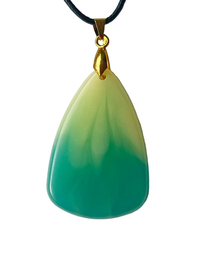 Handcrafted large resin teardrop pendant with soft warm cream upper field flowing through an organic painterly gradient into rich saturated teal-green lower field with a smooth high-gloss domed finish, suspended from a black braided cord with a gold-toned bail.