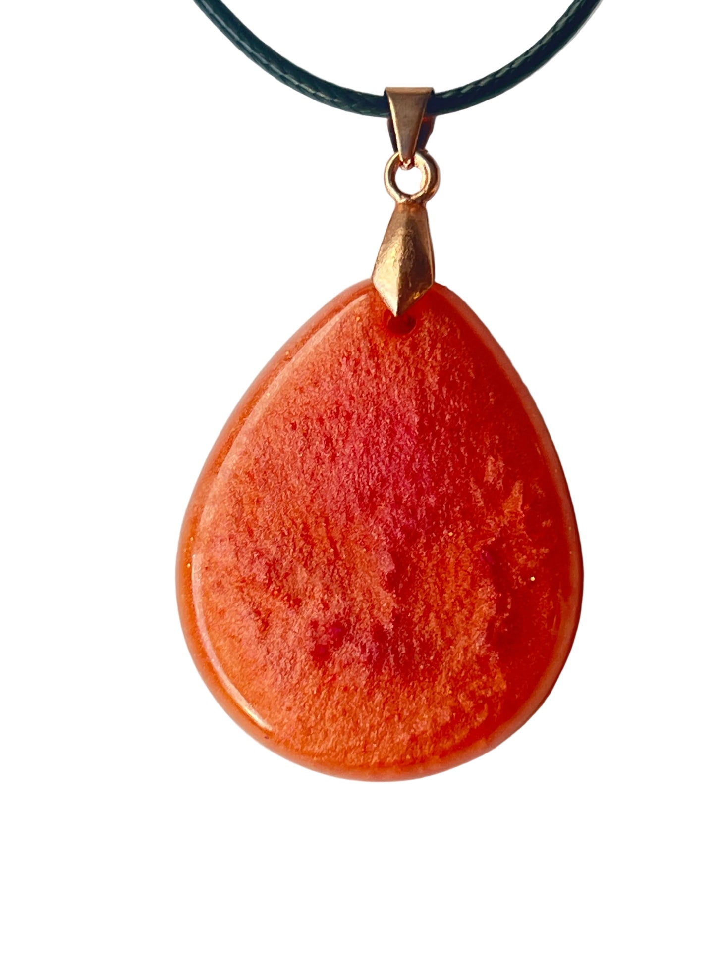 Handcrafted large resin teardrop pendant in rich opaque orange with natural deeper red-orange and brick-red mineral cloud formations throughout and a high-gloss domed finish, suspended from a black braided cord with a rose gold bail.