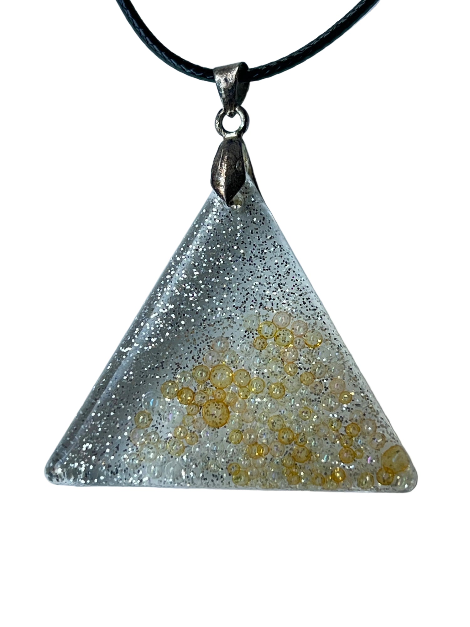 Handcrafted clear translucent resin equilateral triangle pendant with dense ultra-fine silver glitter at the apex and scattered golden micro-bubble spheres in organic clusters throughout the lower field, suspended from a black braided cord with a silver-toned bail.