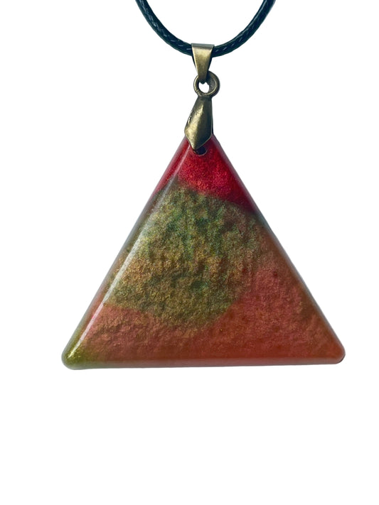 Handcrafted resin equilateral triangle pendant with warm terracotta and burnt-orange lower field, soft olive and moss green mineral cloud formations throughout, and a vivid translucent crimson-red crown at the apex, suspended from a black braided cord with an antiqued brass bail.