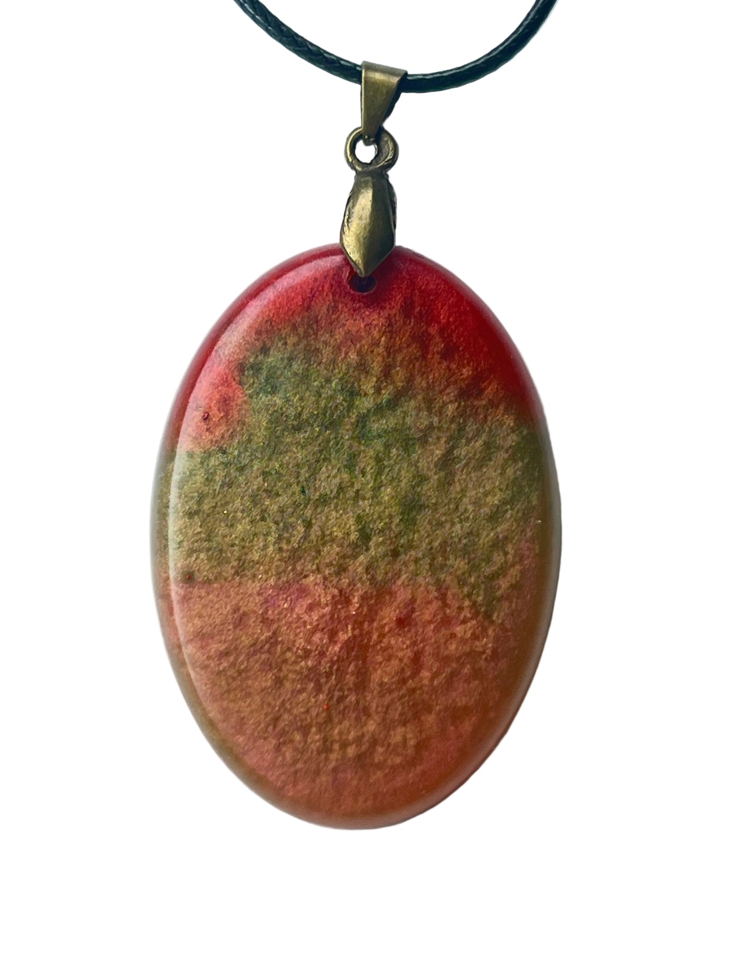 Handcrafted large resin oval pendant in warm red and coral-terracotta with dense olive, khaki, and forest green mineral cloud formations throughout and a high-gloss domed cabochon finish, suspended from a black braided cord with an antiqued brass bail.