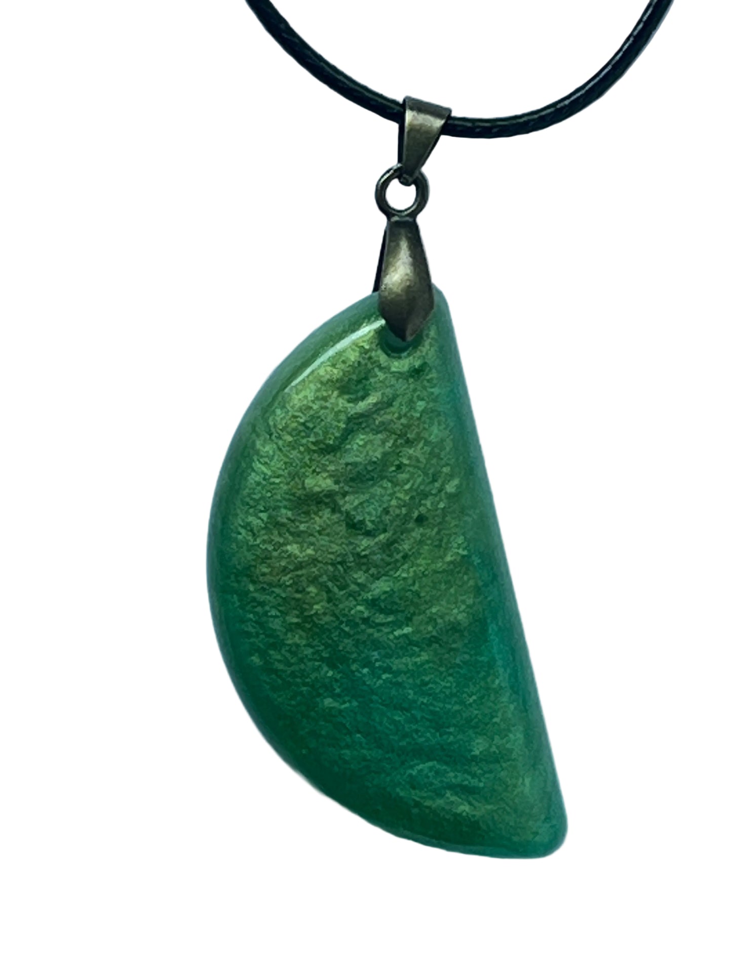Handcrafted pearlescent green resin half-moon pendant shifting between soft chartreuse and deep grass-green, suspended from a black braided cord with an antiqued brass bail.