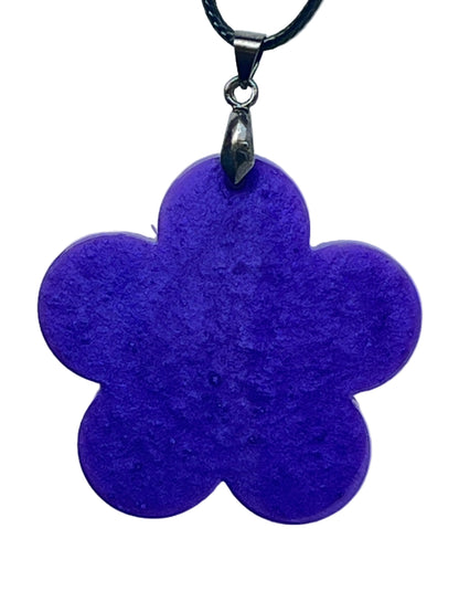 Handcrafted rich opaque electric violet-purple resin five-petal flower pendant with fine pearlescent shimmer throughout, suspended from a black braided cord with a silver-toned bail.