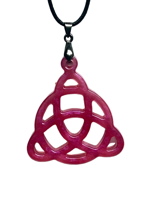 Handcrafted vivid fuchsia and deep rose pink resin triquetra Celtic knot pendant with open cutwork structure and translucent blush interior windows, suspended from a black braided cord with a gunmetal bail.