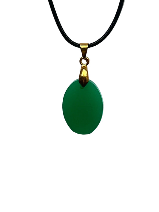A smooth oval-shaped resin pendant in a solid, rich jade green with a soft luminous finish and no inclusions. It hangs from a gold-toned bail on a black braided cord against a pale background.