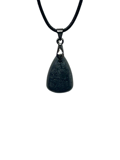 A smooth teardrop-shaped resin pendant in charcoal grey with a soft, mottled, smoke-like texture and faint silvery shimmer. It hangs from a gunmetal bail on a black braided cord against a pale background.