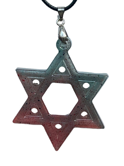 A six-pointed star (hexagram) resin pendant with a gradient from teal and slate at the top points to coral and red at the bottom, scattered with fine black speckles, a single dot on each point, and an open hexagonal center. It hangs from a silver-toned bail on a black braided cord against a pale background.