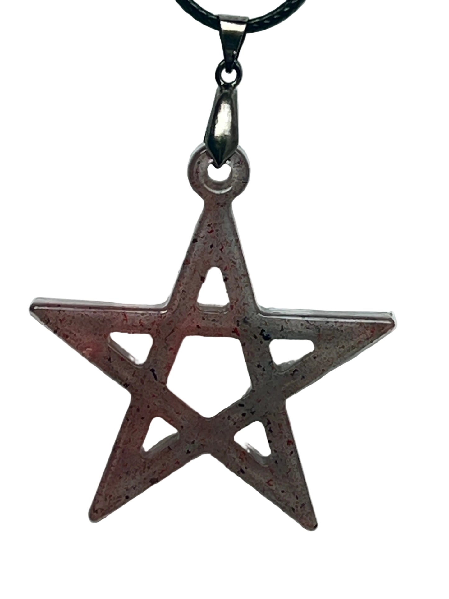 A five-pointed star (pentagram) shaped resin pendant in dusty rose and terracotta with deep crimson speckles, featuring an open cut-out design with five triangular windows around a central pentagon. It hangs from a gunmetal bail on a black braided cord against a pale background.
