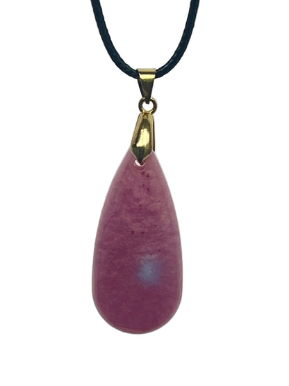 An elongated teardrop-shaped resin pendant in soft dusty mauve-pink with a frosted, mottled texture and subtle rose and berry tones. It hangs from a gold-toned bail on a black braided cord against a pale background.