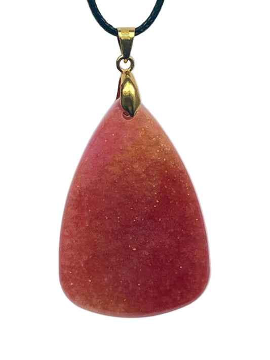 An organic, rounded triangular-shaped resin pendant with a gradient from burnt orange and rust at the base to softer peach at the top, scattered throughout with fine gold sparkle. It hangs from a gold-toned bail on a black braided cord against a pale background.