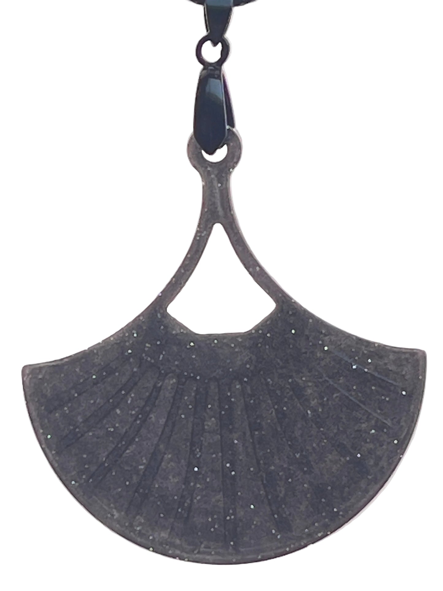 A fan or leaf-shaped resin pendant in deep charcoal grey with fine silver glitter throughout, featuring ribbed vein-like detailing and a small triangular cut-out near the top. It hangs from a gunmetal bail on a black braided cord against a pale background.