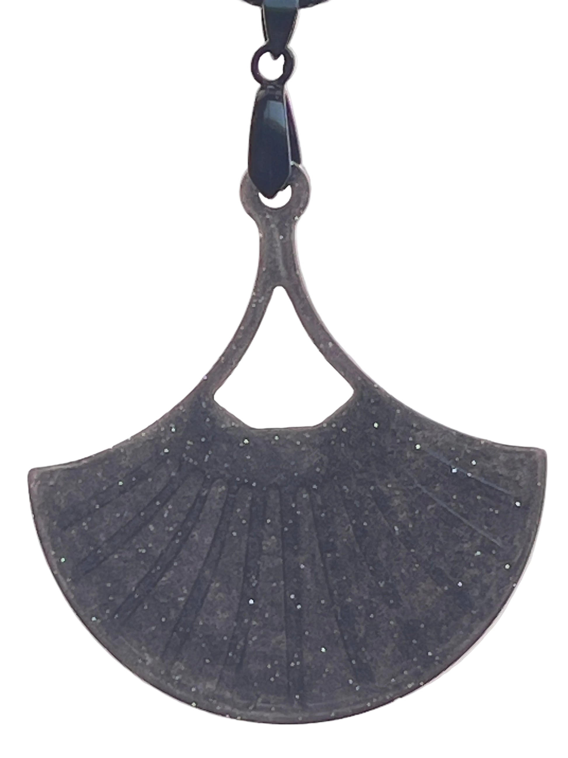 A fan or leaf-shaped resin pendant in deep charcoal grey with fine silver glitter throughout, featuring ribbed vein-like detailing and a small triangular cut-out near the top. It hangs from a gunmetal bail on a black braided cord against a pale background.