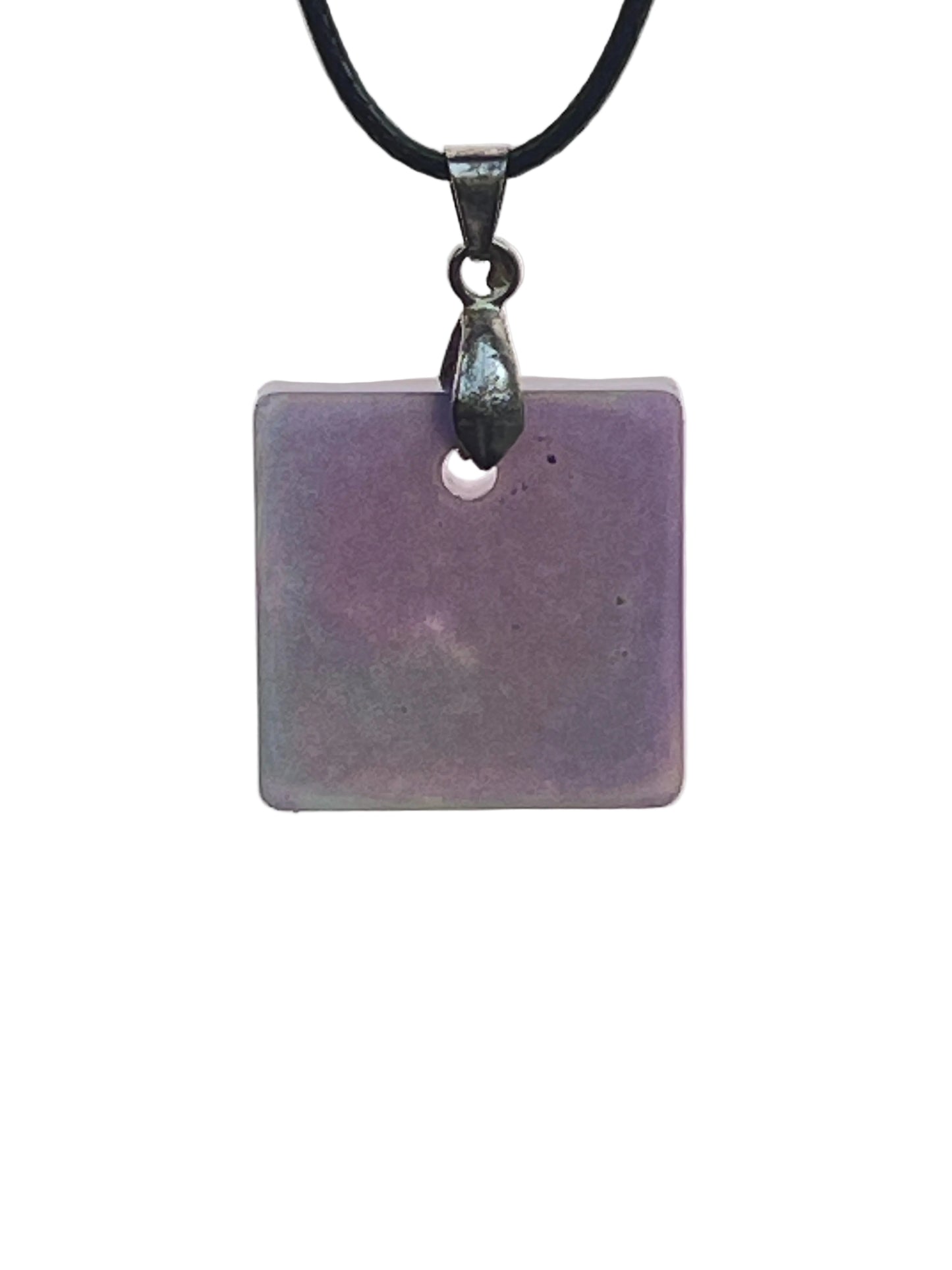 A square resin pendant in soft violet-grey with subtle cloud-like variations of muted plum throughout. It hangs from a gunmetal bail on a black braided cord against a pale background.